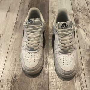 Worn Air Force Ones with black swoosh.
